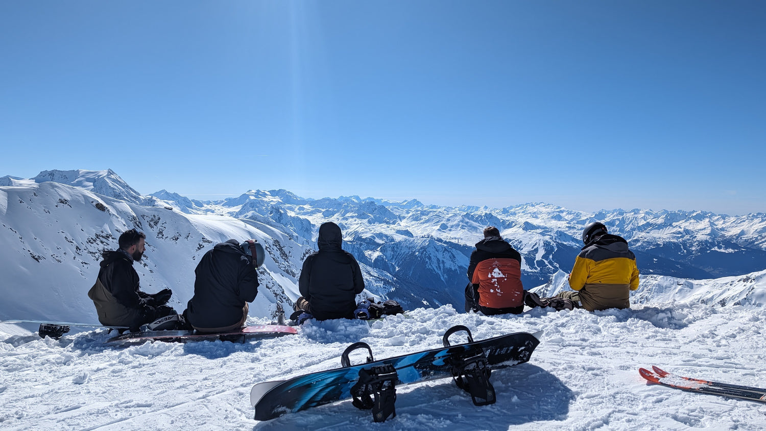 Five friends sat at the top of a snowy mountain range